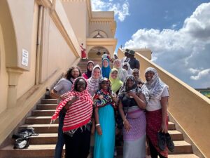 Valeria Valles Casteñeda (green headscarf) Makenzie Patterson (blue headscarf) Jorja Whyte (white headscarf and glasses) with other PLP/CSU students and university students from Benedict College (HBCU in South Carolina) at the Gaddafi National Mosque in Kampala, Uganda.